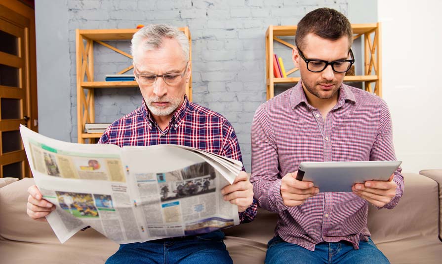 Молодой и пожилой инвесторы читают статью для инвесторов