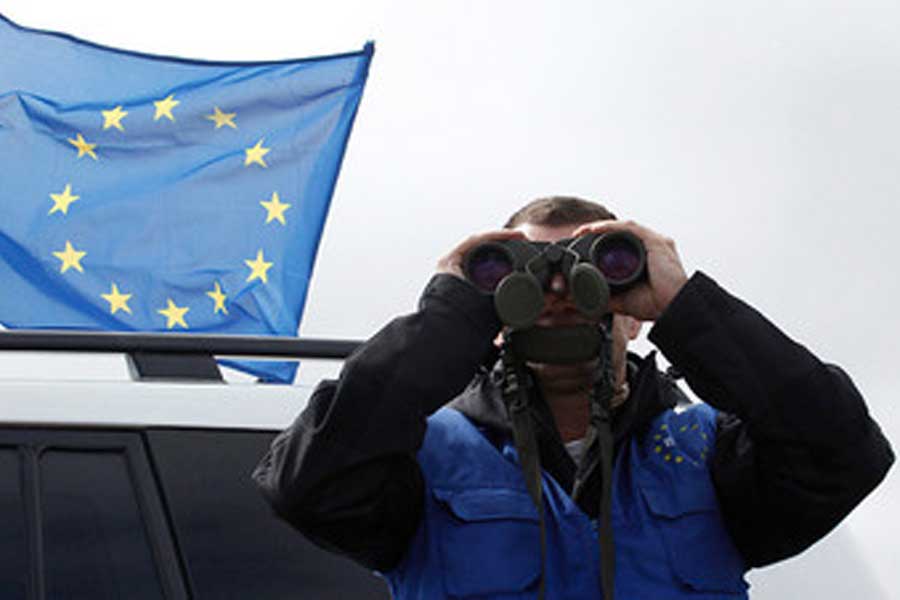 Флаг ЕС и мужчина смотрит в бинокль
